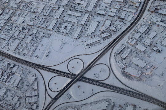 Aerial view of a cloverleaf interchange and cityscape in winter; Calgary, Alberta, Canada