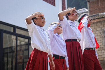 Indonesian elementary student wearing uniform gesture saluting.  Ceremony of Indonesia Independence...