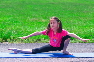 Young sporty attractive girl doing warmup exercise. Working out outdoors. Sport, healthy lifestyle concept.