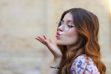 Portrait of an attractive young girl, air kiss.