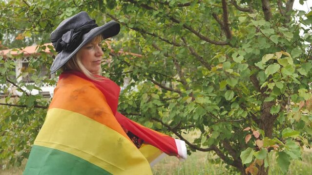 A woman with an LGBT flag on her face. Young crying woman with LGBT flag on her cheek. The concept of violation of the rights and equality of LGBT persons. A young woman with short hair covering part 