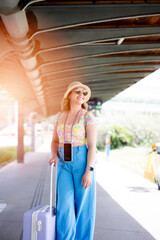 Young tourist with hat and sunglasses at train station
