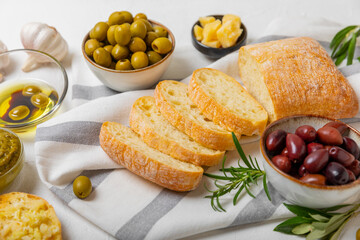 Italian ciabatta bread with olives, garlic, parmesan and rosemary on a light concrete background. Tasty food. Aperitif. Place for text. copy space. Delicacy. Bon appetit.