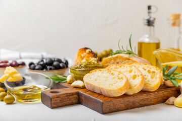 Italian ciabatta bread with olives, garlic, parmesan and rosemary on a light concrete background. Tasty food. Aperitif. Place for text. copy space. Delicacy. Bon appetit.
