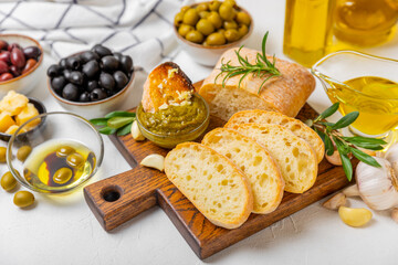 Italian ciabatta bread with olives, garlic, parmesan and rosemary on a light concrete background. Tasty food. Aperitif. Place for text. copy space. Delicacy. Bon appetit.