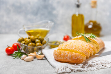 Italian ciabatta bread with olives, garlic, parmesan and rosemary on a light concrete background. Tasty food. Aperitif. Place for text. copy space. Delicacy. Bon appetit.