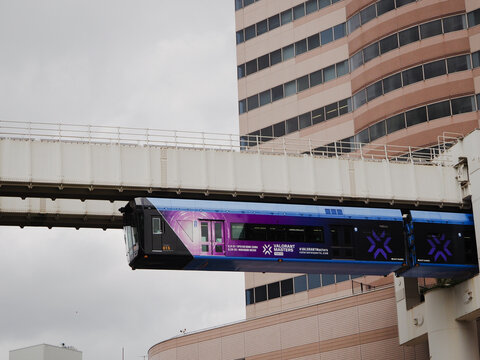 CHIBA, JAPAN - June 20, 2023: Train operating on Chiba's Urban Monorail with Sogo department store and Sen City Tower in the background. Its livery advertises the Valorant Masters Tokyo esports event 