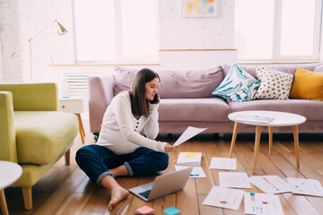 Pregnant woman working with documents and talking on smartphone