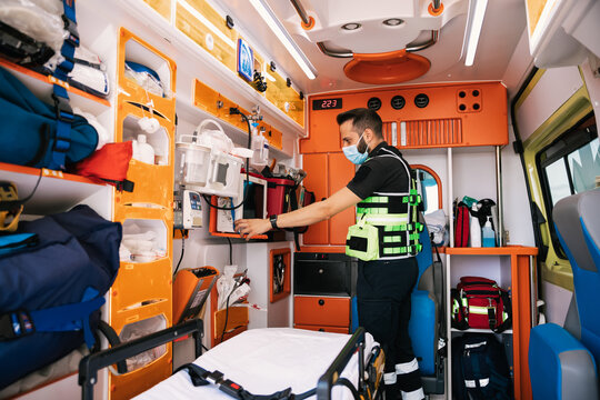 Emergency medical technician standing in ambulance car