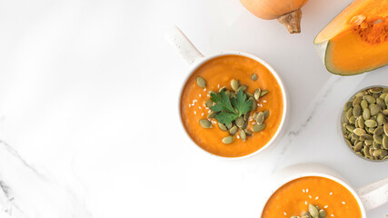 Mugs of warm pumpkin soup. The concept of the autumn menu. Autumn recipes. Copy space