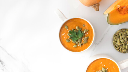 Mugs of warm pumpkin soup. The concept of the autumn menu. Autumn recipes. Copy space