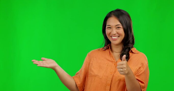 Happy asian woman, palm and thumbs up on green screen for success against a studio background. Portrait of female person with smile and thumb emoji, yes sign or like for approval in advertisement