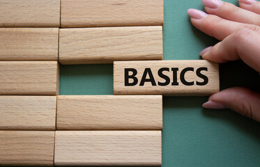 Basics symbol. Concept word Basics on wooden blocks. Businessman hand. Beautiful grey green...