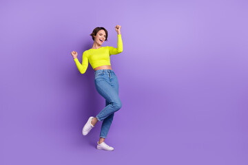 Full body photo of crazy young lady wearing levis jeans calvin klein crop top celebrating summer sale isolated on purple color background
