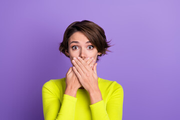 Portrait of impressed nervous anxious person arms palms cover mute mouth wear lime shirt isolated on purple color background