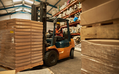 African female forklift operator moving stock around a warehouse