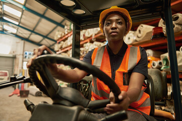African female forklift operator at work in a textile warehouse