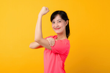 Portrait beautiful young asian sports fitness woman happy smile wearing pink sportswear posing exercise training workout isolated on yellow studio background. wellbeing and healthy lifestyle concept.