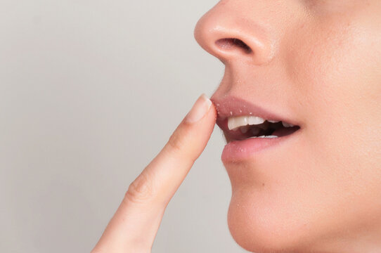 Crop woman exfoliating lips with sugar scrub