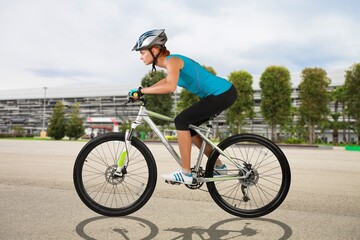 Obraz premium Young woman ride a bicycle on nature background