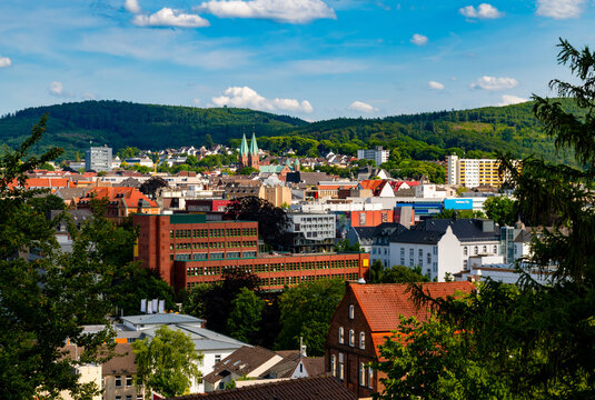 Panoramic view of Iserlohn town centre in rural Sauerland with hills and forests in the background. Colorful old and modern commercial and residential buildings, churches and factorys and offices.
