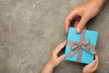 Father's day gift with daughter or son holding dad's hands giving present box to tell I love you...