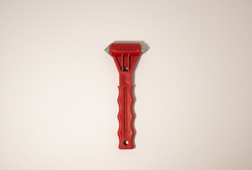 red emergency glass breaker hammer on a white background