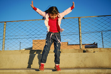 happy latina girl jumping in an outdoor park