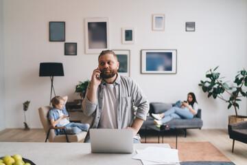Man working remotely near family