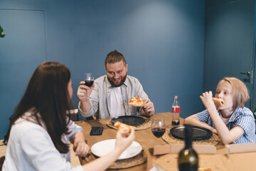 Cheerful man with wine having dinner with family