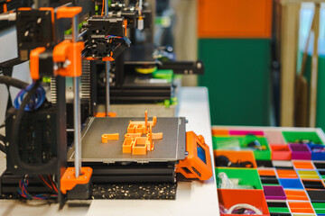 3d printer above drawer with 3d printing parts. Home element factory. Creative 3d design. Colorful compartments in a cabinet with organized parts. 