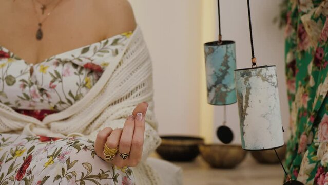 Buddhist music therapy, ritual closeup. Female hands is making sound, vibration from Koshi Chimes. Spiritual woman performing guided meditation, relaxing sound therapy