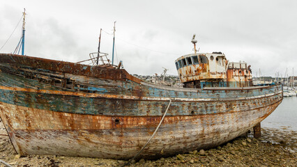 Shipwreck with colorful peeled paint in the ship graveyard of Camaret-sur-Mer, Finisterre, Brittany, France