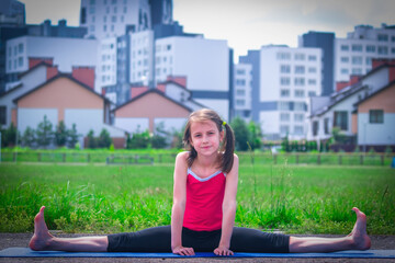 Fototapeta premium Young sporty attractive girl doing warmup exercise and stretch her legs. Sports training in urban conditions.