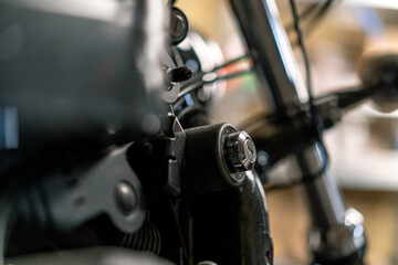 Fototapeta na wymiar Creative authentic motorcycle workshop Biker mechanic in garage putting key into power box to start motorcycle close up