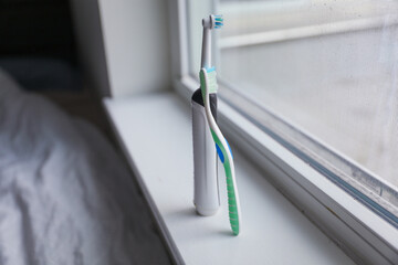 oothbrush and an electronic toothbrush side by side, representing oral hygiene, modern dental care,...