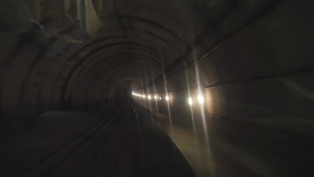 Time lapse. A view from inside a train moving through underground tunnels.
