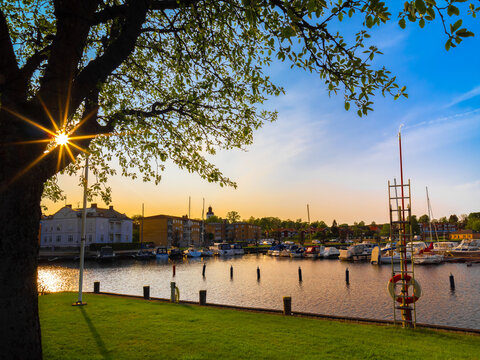 An idyllic evening with sunburst at golden hour in the marina of the Swedish city of Amal