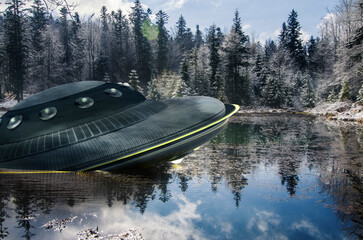 UFO, broken space saucer lies in the water on the banks of a river or lake after an accident and...