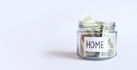 Money in a glass jar. Save money to renovate or buy a house. Dollars in a piggy bank