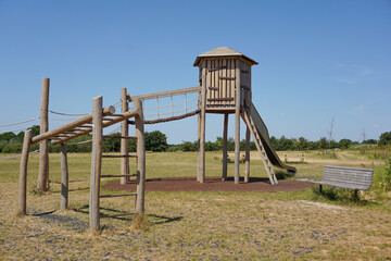 Children's playground with wooden climbing frame and slide. Fun equipment in play park 