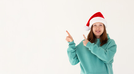 Fototapeta na wymiar Photo of charming pregnant lovely pretty nice girl in santa claus headwear point index finger copyspace, indicate x-mas jolly holly advertisement isolated over white color background