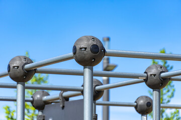 Outdoor sports ground in the city park. Street exercise equipment with horizontal bars, columns and balances. Street gym for all active people. Concept of fitness and healthy lifestyle. Details metal.