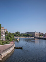 Stone parterre, round net fishing boat, piers and bridge at the bay Str&ouml;mmen, a sunny summer day in Stockholm