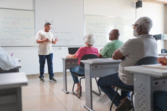 professor Brasileiro dando aula para uma turma de adultos e idosos em uma escola no Brasil
