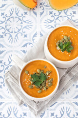 Mugs of warm pumpkin soup. The concept of the autumn menu. Autumn recipes.