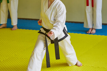 Girl doing karate. Girl's hands in kimono with bright manicure. Girl learning self-defense.