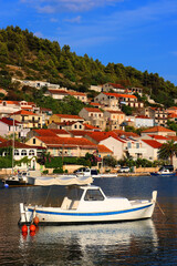 Obraz premium Small fishing boat and picturesque skyline in Vela Luka, island Korcula, Croatia.