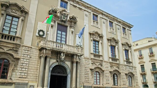Beautiful historical building with flags in Catania, Italy.
View of the old town with a columned facade, domed roof, frescoes, and stunning paintings in Italy.