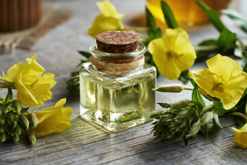 Evening primrose oil in a glass bottle with fresh flowers